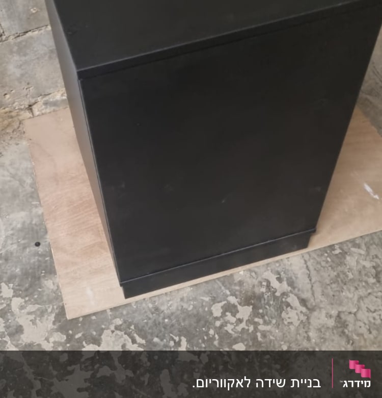 ארון שחור עומד על רצפת בטון